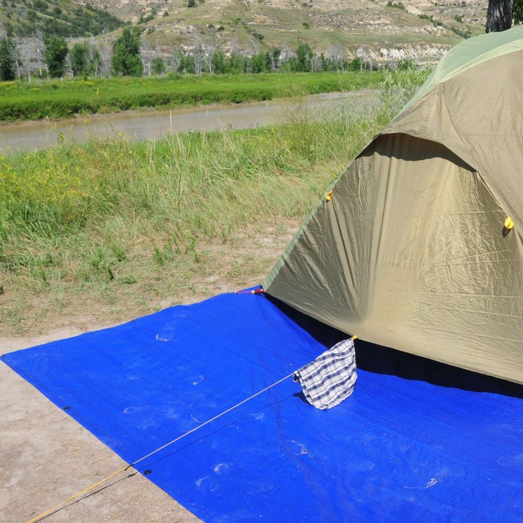 Example of using a larger tent footprint than your tent for extra covered ground space for storage while camping. 