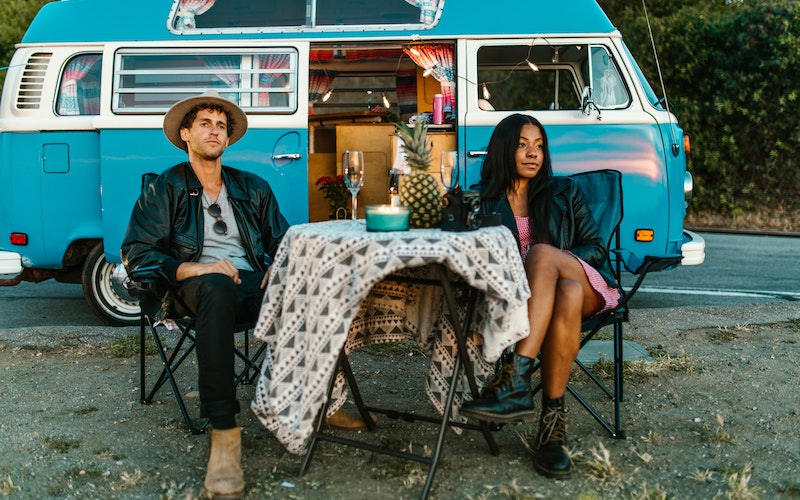 two people camping in a blue van