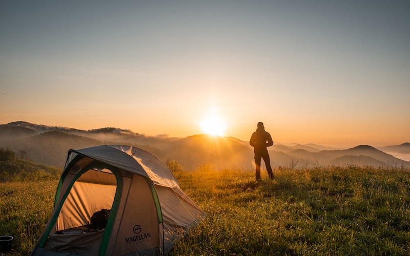 a man enjoying the sunset while dry camping