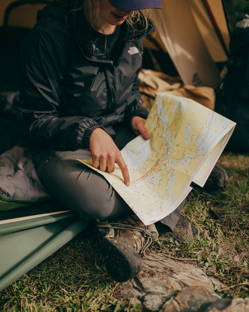 a woman looking at a map while camping