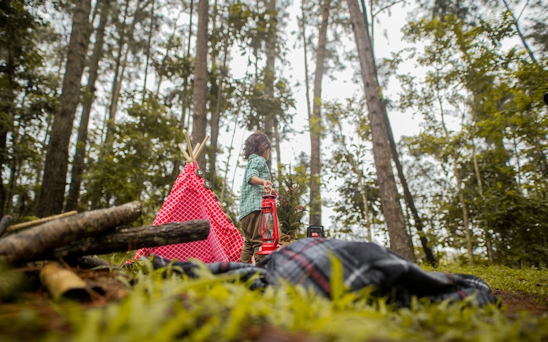 a woman camping in a tent in the woods